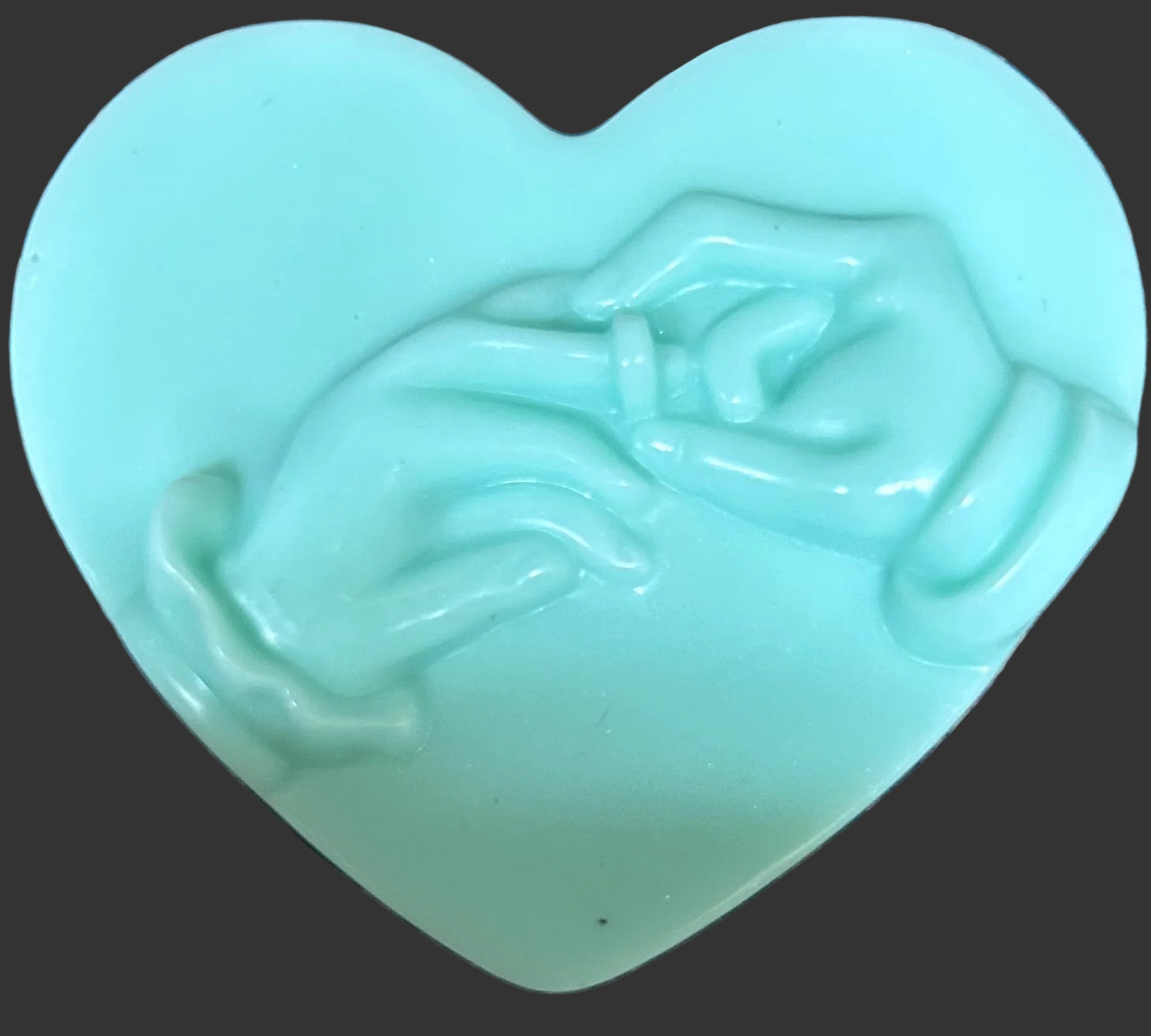 Heart-shaped green soap with a design 