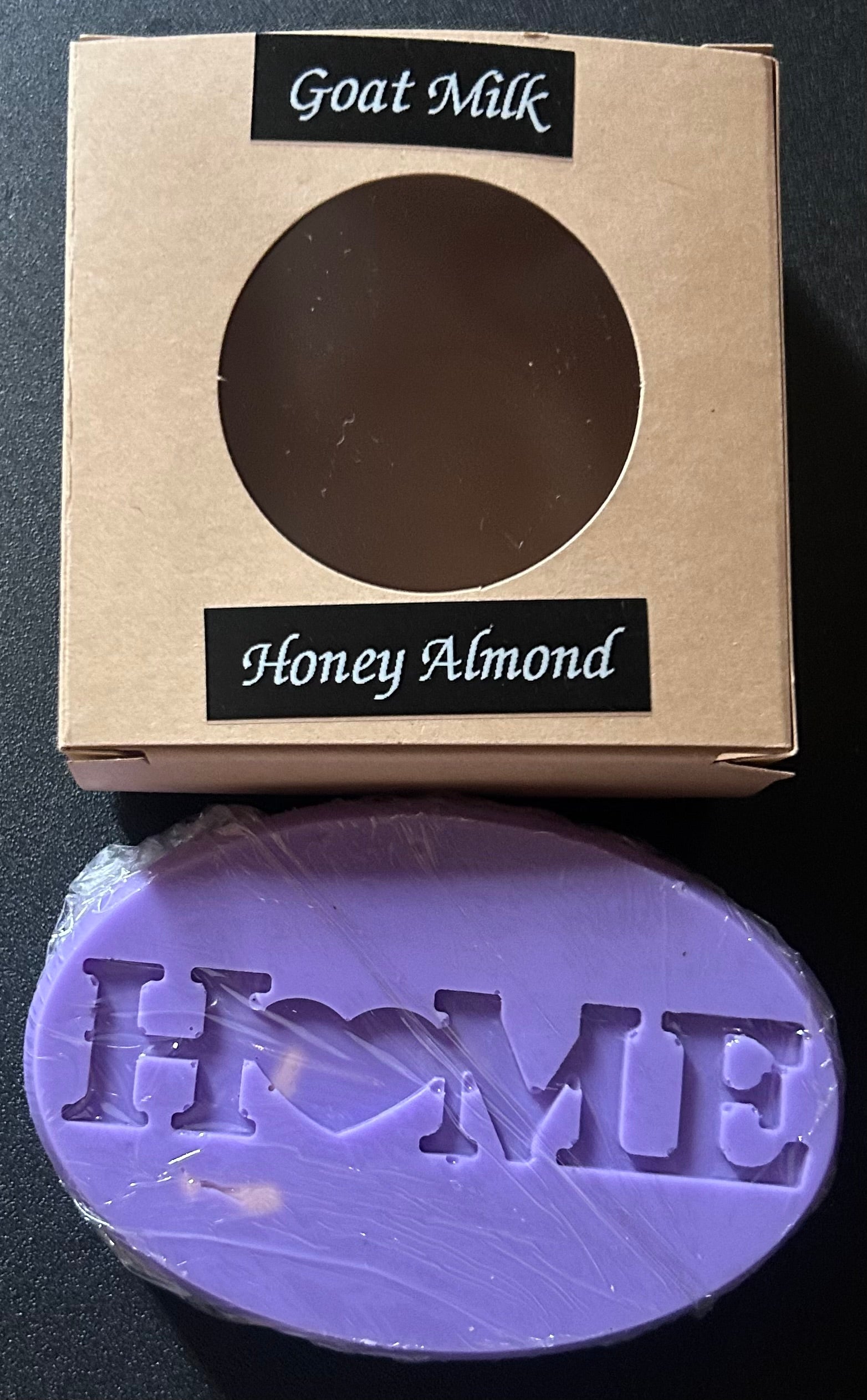 Purple soap bar with 'HOME' branding - 'Goat Milk Honey Almond'.