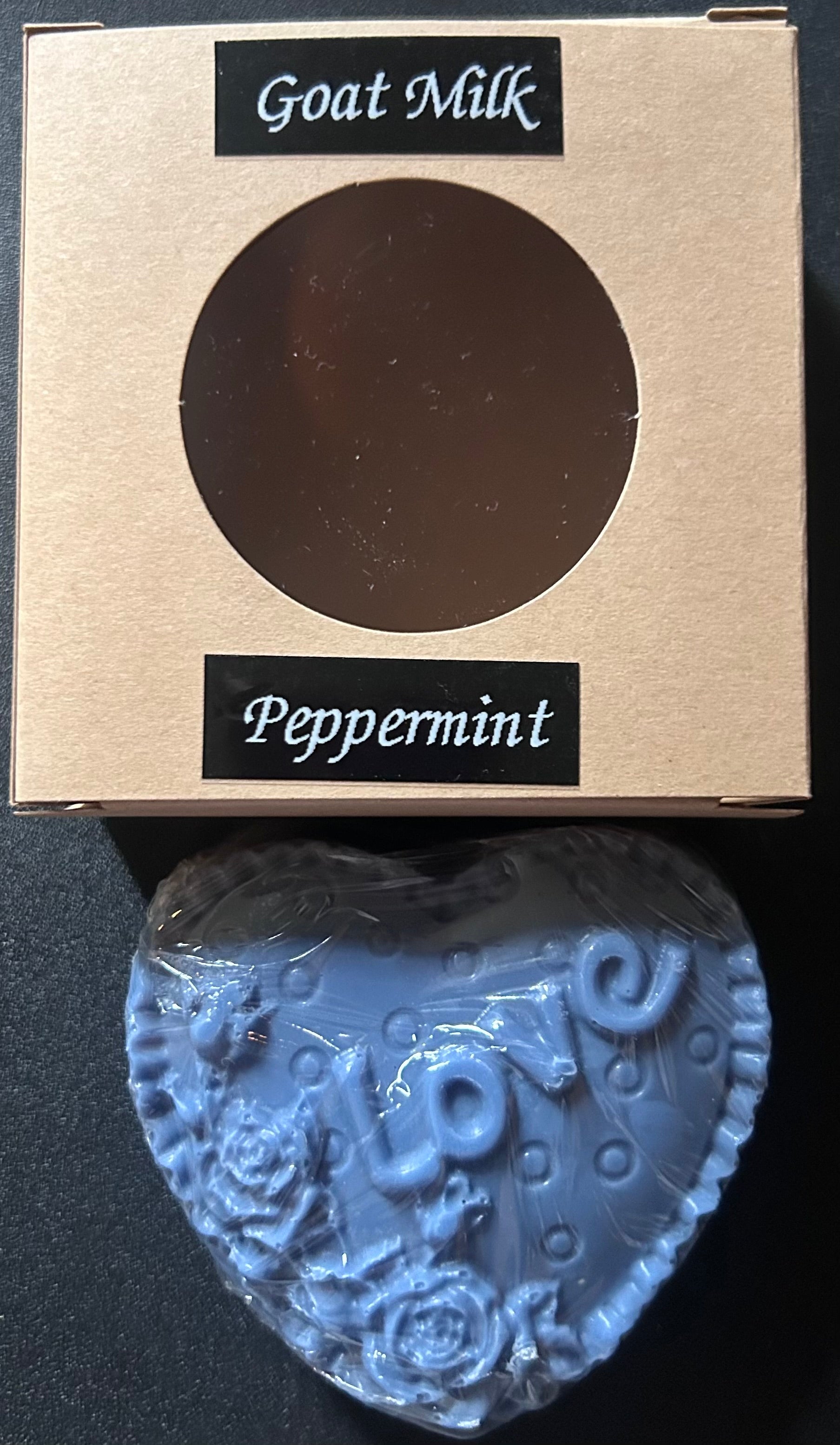 Heart-shaped blue soap with 'LOVE' text and floral designs, 'Goat Milk Peppermint'.